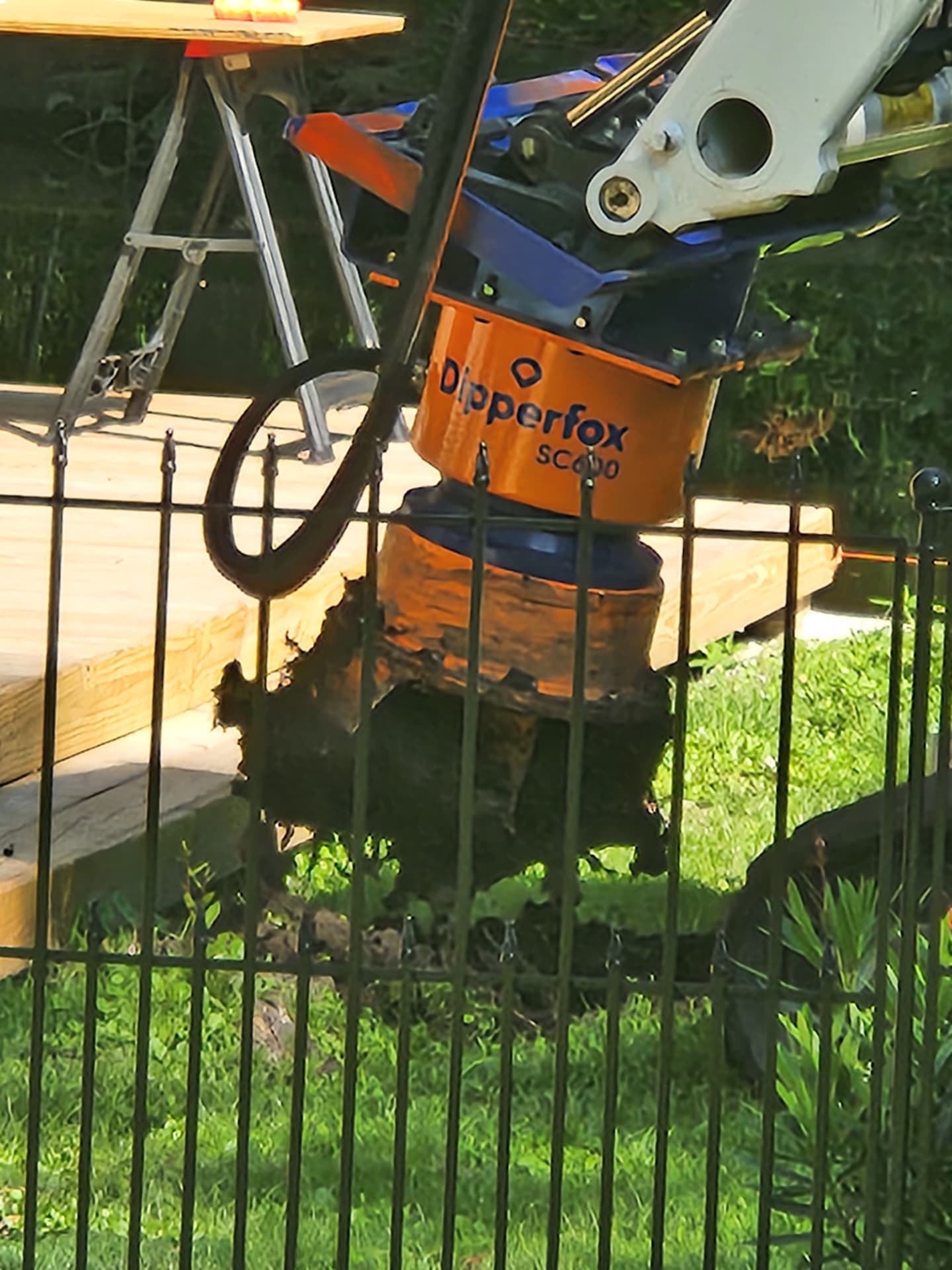 Dipperfox stump grinder attachment grinding a stump