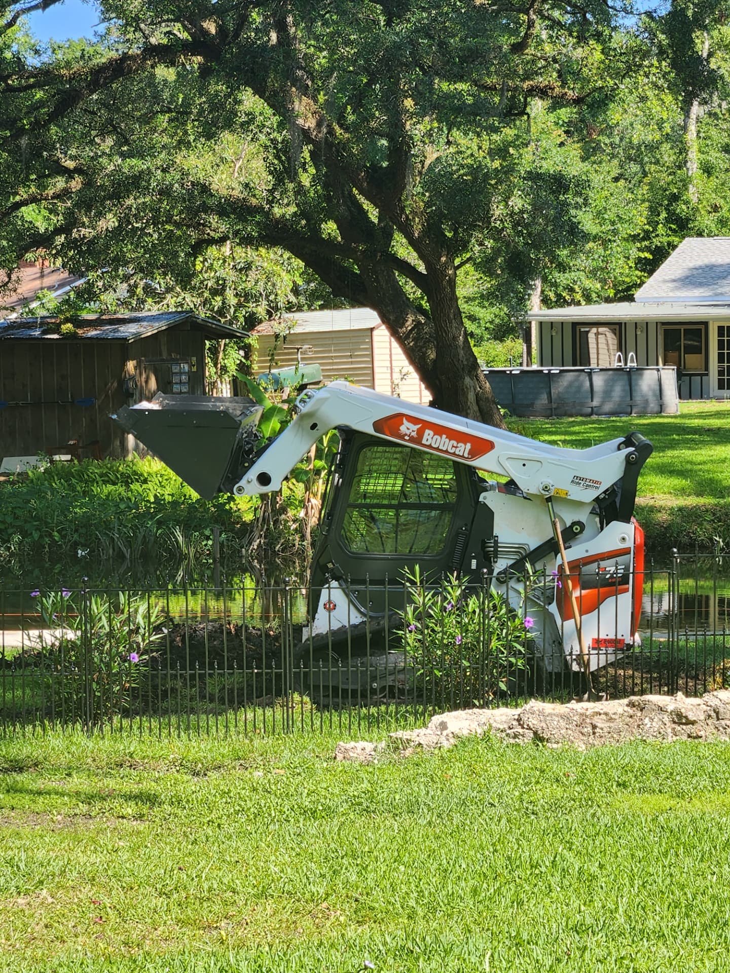 Track loader with mulching attachment on a cleared property