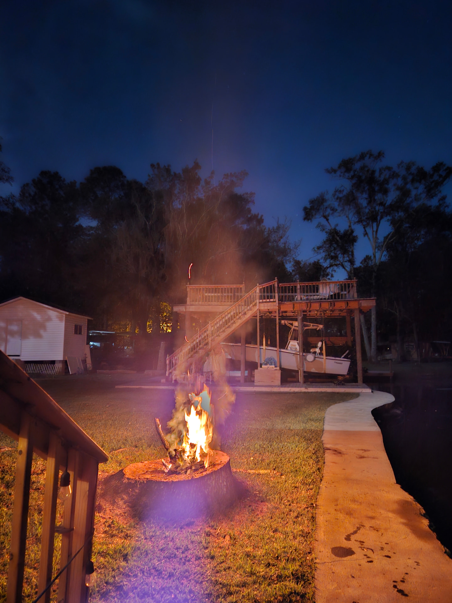 Large stump repurposed as a fire pit in a yard